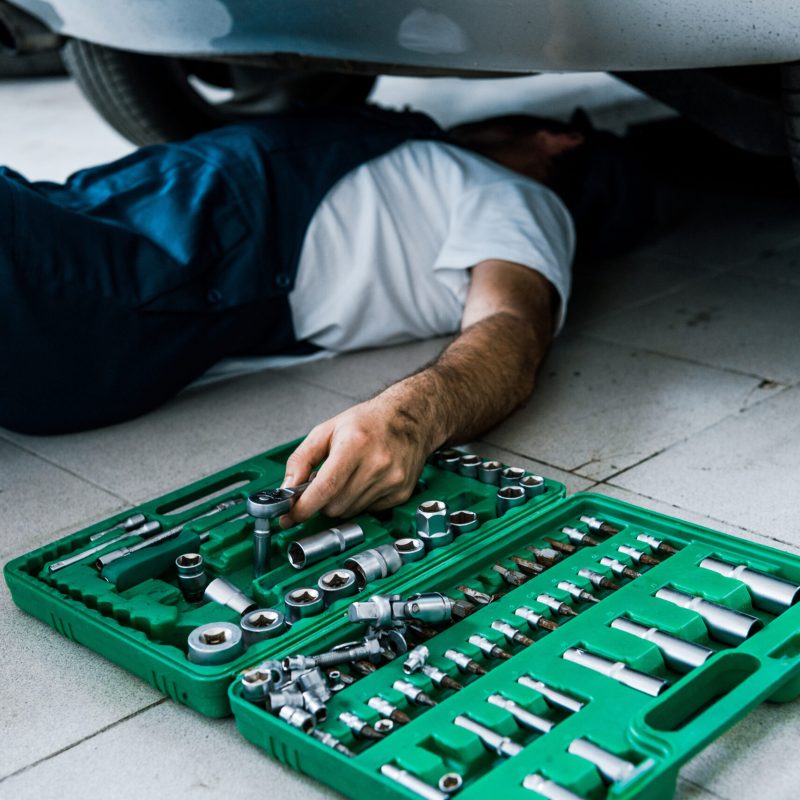 cropped view of car mechanic repairing car in car service